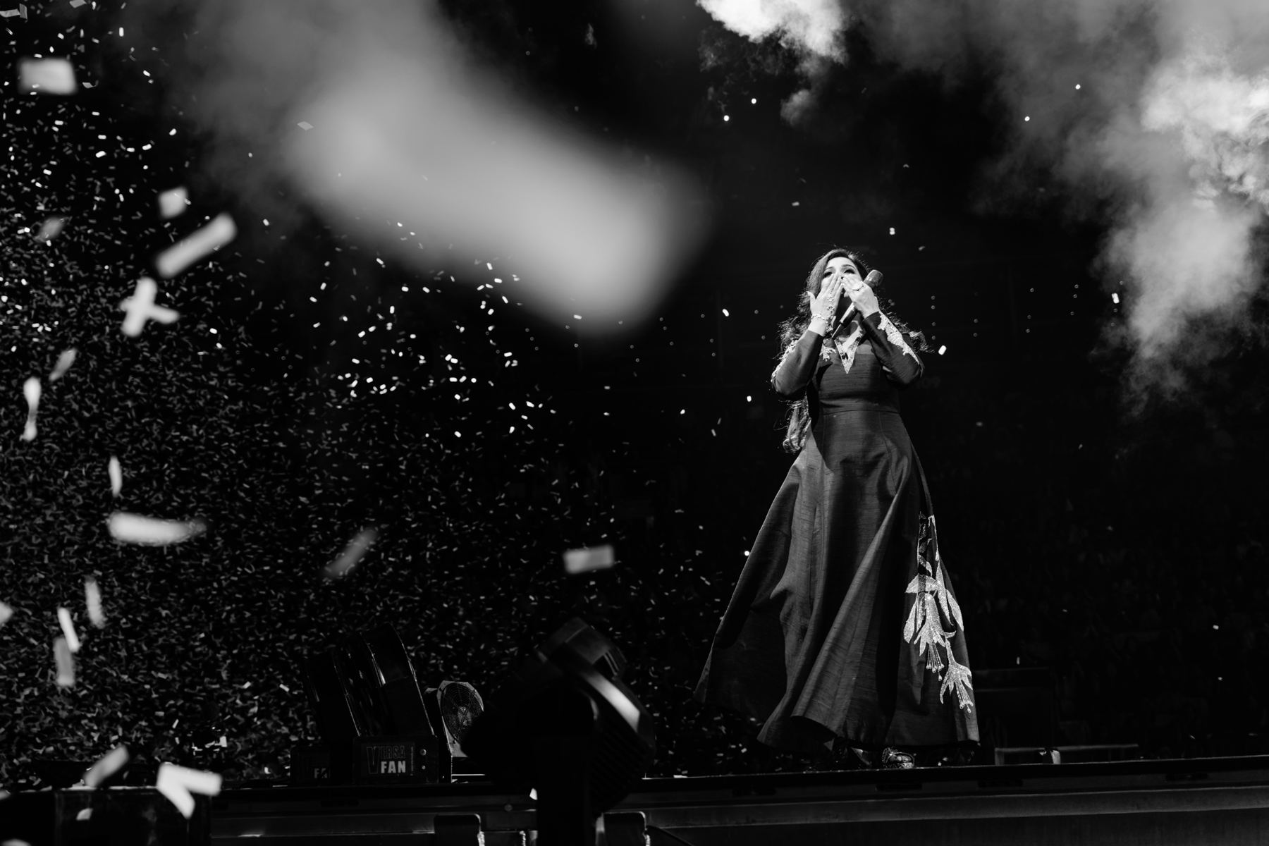 Singer blowing a kiss to the crowd through a cloud of confetti